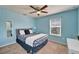 Bedroom with blue walls, ceiling fan and a comfortable bed with patterned bedding at 3019 Old Fulton Pl, Brandon, FL 33510