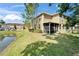 Back of townhome featuring a screened patio overlooking a green lawn and a serene pond at 3019 Old Fulton Pl, Brandon, FL 33510
