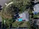 A lush aerial view showcases this property's roof, pool and mature trees on a well manicured lawn at 325 Orangeview Ave, Clearwater, FL 33755
