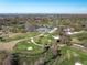 Picturesque aerial view of a golf course and clubhouse amidst green trees, with a city skyline in the distance at 325 Orangeview Ave, Clearwater, FL 33755