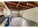 Unfinished basement with concrete floor, wooden ceiling beams and an access door to the outside at 325 Orangeview Ave, Clearwater, FL 33755