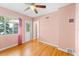 Bedroom with hardwood floors, a ceiling fan, a window, and doorway leading to other rooms at 325 Orangeview Ave, Clearwater, FL 33755