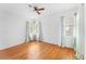 Bright bedroom featuring hardwood floors, two windows with curtains, and ample natural light at 325 Orangeview Ave, Clearwater, FL 33755