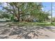 Exterior view of a home with a lush green lawn, mature trees, and a welcoming neighborhood setting at 325 Orangeview Ave, Clearwater, FL 33755