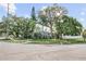 A cozy home on a corner lot, surrounded by mature trees and a well-manicured lawn, offering a serene and private setting at 325 Orangeview Ave, Clearwater, FL 33755