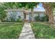 Charming single-story home with a landscaped front yard and inviting entryway with decorative tile steps at 325 Orangeview Ave, Clearwater, FL 33755