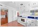 Retro kitchen with white cabinets, appliances, and a window that offers natural light at 325 Orangeview Ave, Clearwater, FL 33755