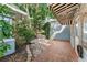 Beautiful side yard with a mix of stone and brick pathways, lush greenery, and unique architectural details, creating a charming outdoor space at 325 Orangeview Ave, Clearwater, FL 33755
