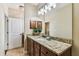 Bathroom vanity with granite countertop, dark wood cabinets, and a decorative mirror at 405 S Tampania Ave # A, Tampa, FL 33609