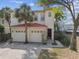 Two-story home with a tile roof, two-car garage, and a lush landscape in a serene neighborhood at 405 S Tampania Ave # A, Tampa, FL 33609