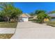 Well-maintained single-story home featuring a spacious driveway and mature landscaping at 408 Valencia Park Dr, Seffner, FL 33584