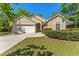 Charming single-story home with a well-manicured lawn, mature trees, and a two-car garage at 408 Valencia Park Dr, Seffner, FL 33584
