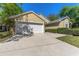 Attached two-car garage with a spacious driveway and well-maintained landscaping at 408 Valencia Park Dr, Seffner, FL 33584