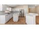 Well-lit kitchen featuring white cabinetry, stainless steel appliances, a breakfast bar, and vinyl floors at 408 Valencia Park Dr, Seffner, FL 33584
