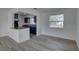 Bright living room with modern vinyl floors and a pass-through to the kitchen with blue cabinets at 417 Hollyhock Ln, Spring Hill, FL 34606