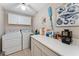 Practical laundry room with washer, dryer, ample counter space and storage cabinets at 419 Richards Ave, Clearwater, FL 33755