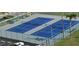 Aerial view of blue and gray tennis courts surrounded by green benches at 4525 Cove Cir # 304, St Petersburg, FL 33708