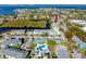 Condo aerial view featuring tennis courts, pool, landscaping and waterway views at 455 Alt 19 S # 162, Palm Harbor, FL 34683