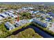 Community aerial view with pool, tennis courts, and pond near condo building at 455 Alt 19 S # 162, Palm Harbor, FL 34683