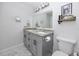 Bathroom with a double vanity, a large mirror, and gray cabinets at 455 Alt 19 S # 162, Palm Harbor, FL 34683