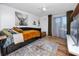 Cozy bedroom with a daybed, wood floors, large art piece, and access to a balcony through glass doors at 455 Alt 19 S # 162, Palm Harbor, FL 34683