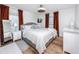 Bright bedroom with hardwood floors, modern ceiling fan, and large windows with rust colored drapes at 455 Alt 19 S # 162, Palm Harbor, FL 34683