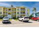 Inviting three-story condo building featuring balconies, palm trees, and convenient parking spaces for residents and guests at 455 Alt 19 S # 162, Palm Harbor, FL 34683