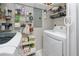 Well-organized laundry room with white washer and dryer, shelving, and storage for supplies at 455 Alt 19 S # 162, Palm Harbor, FL 34683