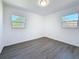 Bright bedroom featuring two windows, gray flooring, and white walls at 4716 Town N Country Blvd, Tampa, FL 33615