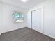 Bright bedroom with modern flooring, window view, and a closet at 4716 Town N Country Blvd, Tampa, FL 33615