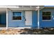 Close-up of the front door, showcasing the covered porch and surrounding windows at 4716 Town N Country Blvd, Tampa, FL 33615