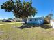 Charming blue home with well-kept lawn and a large tree providing shade at 4716 Town N Country Blvd, Tampa, FL 33615