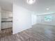 Bright living room featuring modern gray flooring, white walls, and views into the kitchen area at 4716 Town N Country Blvd, Tampa, FL 33615
