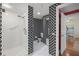 Modern bathroom with a walk-in shower featuring stylish black and white patterned accents at 4801 Osprey S Dr # 404, St Petersburg, FL 33711