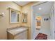 Well-lit bathroom with granite countertop, framed mirror, and neutral wallpaper at 4801 Osprey S Dr # 404, St Petersburg, FL 33711