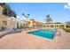Community pool with brick deck, lake view, and pergola, nestled amongst green space, offering a tranquil retreat at 4801 Osprey S Dr # 404, St Petersburg, FL 33711