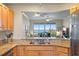 Bright kitchen with stainless steel appliances, light wood cabinets, and granite countertops overlooking the beautiful outside scenery at 4801 Osprey S Dr # 404, St Petersburg, FL 33711
