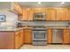 Bright kitchen with stainless steel appliances, light wood cabinets, granite countertops, and light tile floors at 4801 Osprey S Dr # 404, St Petersburg, FL 33711