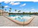 Inviting community pool surrounded by palm trees, sun loungers, and tropical greenery, creating a resort-like atmosphere at 4900 Brittany S Dr # 205, St Petersburg, FL 33715