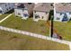 An aerial view of the backyard featuring a white fence, lush green grass and the home's exterior at 5764 Hollingworth Trl, Wesley Chapel, FL 33545