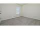 This is a bright, carpeted bedroom with a large window offering plenty of natural light at 5764 Hollingworth Trl, Wesley Chapel, FL 33545