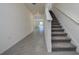 Open hallway features ceramic tile flooring and a staircase leading to the upper level of the home at 5764 Hollingworth Trl, Wesley Chapel, FL 33545