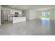 Open-concept kitchen and living area with ceramic tile flooring and bright natural light at 5764 Hollingworth Trl, Wesley Chapel, FL 33545