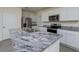 Close-up of the kitchen island showcasing the granite countertops and stainless steel sink at 5764 Hollingworth Trl, Wesley Chapel, FL 33545