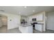 Modern kitchen island featuring granite countertops, stainless steel appliances, and white cabinetry at 5764 Hollingworth Trl, Wesley Chapel, FL 33545