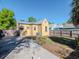 Exterior showcasing a yellow house with a backyard, fence, and driveway at 5807 N Miami Pl, Tampa, FL 33604