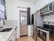 Modern kitchen featuring stainless steel appliances, and black-and-white patterned backsplash at 5807 N Miami Pl, Tampa, FL 33604