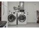 Bright laundry room with washer, dryer, microwave, and white door at 6360 17Th S St, St Petersburg, FL 33712