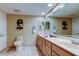 A bright bathroom featuring double sinks, lots of cabinet space, and a large mirror at 6600 Sunset Way # 112, St Pete Beach, FL 33706