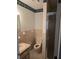 Functional bathroom features a walk-in shower, a vanity with ample counter space, and decorative wallpaper at 6704 Hickorywood Ln # 2B, New Port Richey, FL 34653